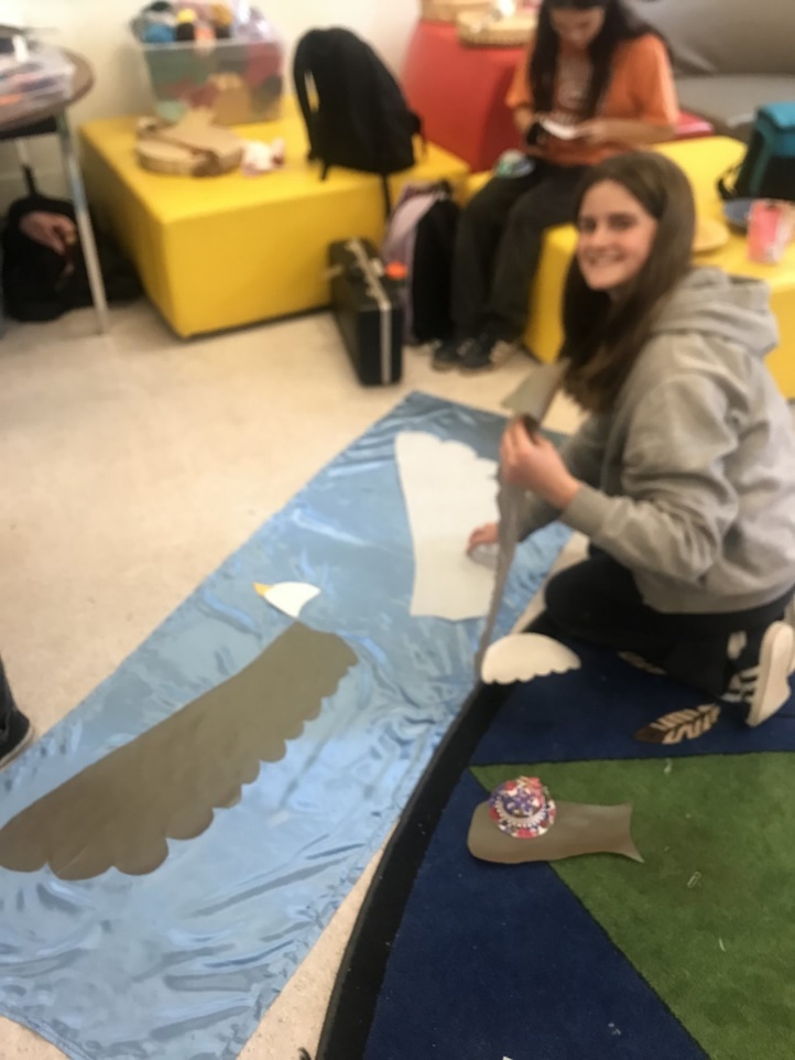 A person sitting on the floor with a blue blanket

Description automatically generated