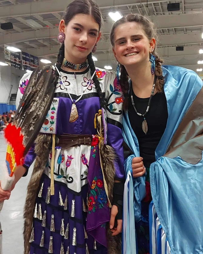 Two women in traditional clothing

Description automatically generated