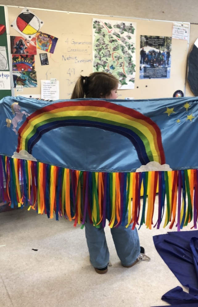 A person holding a rainbow flag

Description automatically generated