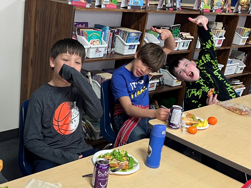 A group of boys sitting at a table with food and drinks

AI-generated content may be incorrect.