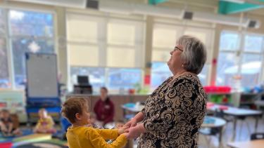 a grandparent dances with a student at a winter feast